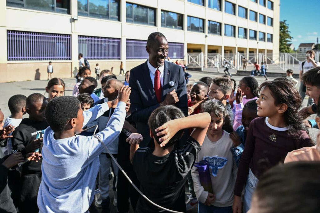 Bally Bagayoko entouré d'élèves dans la cour d'une école de Saint-Denis–Pierrefitte lors de la rentrée scolaire